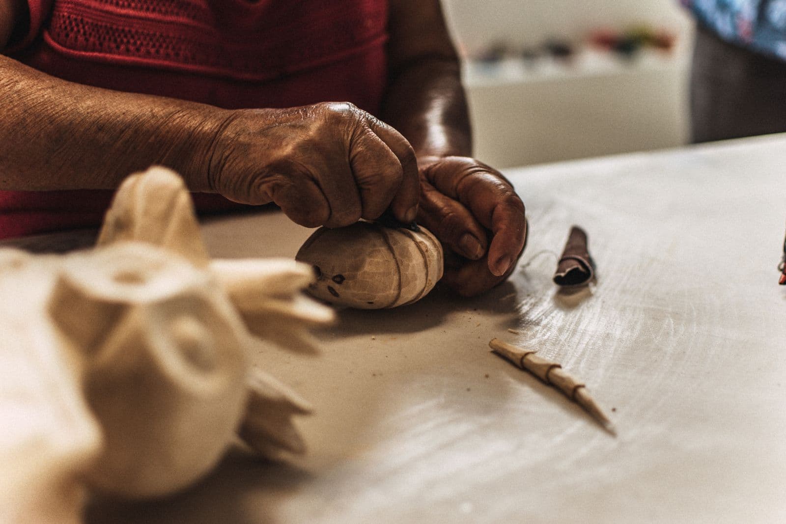 A maker carving a wooden craft by hand